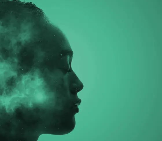 A teal silhouette of a face in profile, filled with soft smoke